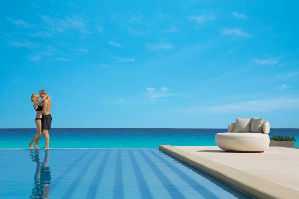 Couple by an infinity pool overlooking the ocean