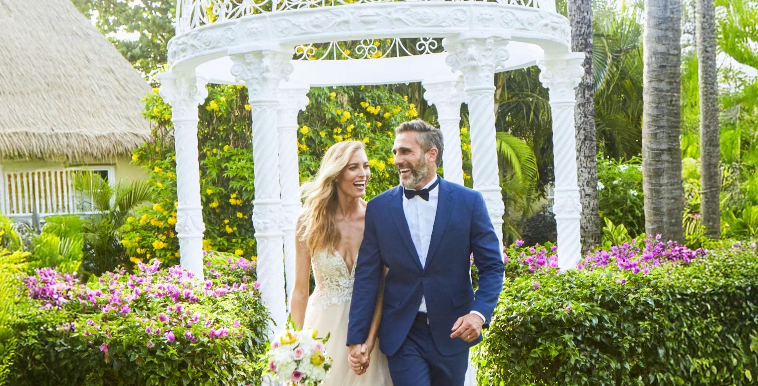 Couple walking through a lush resort garden
