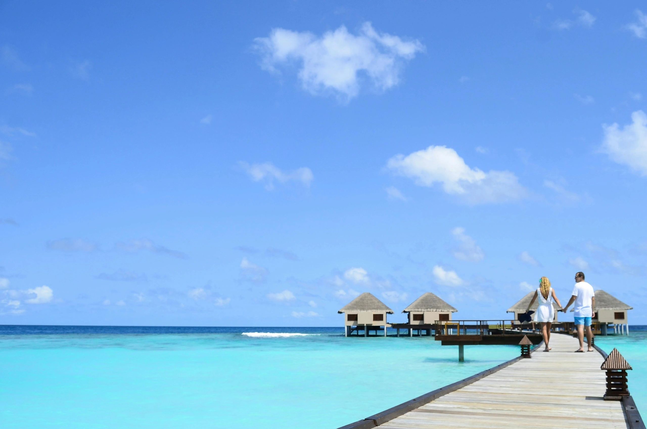 Wooden pier leading to villas over turquoise water