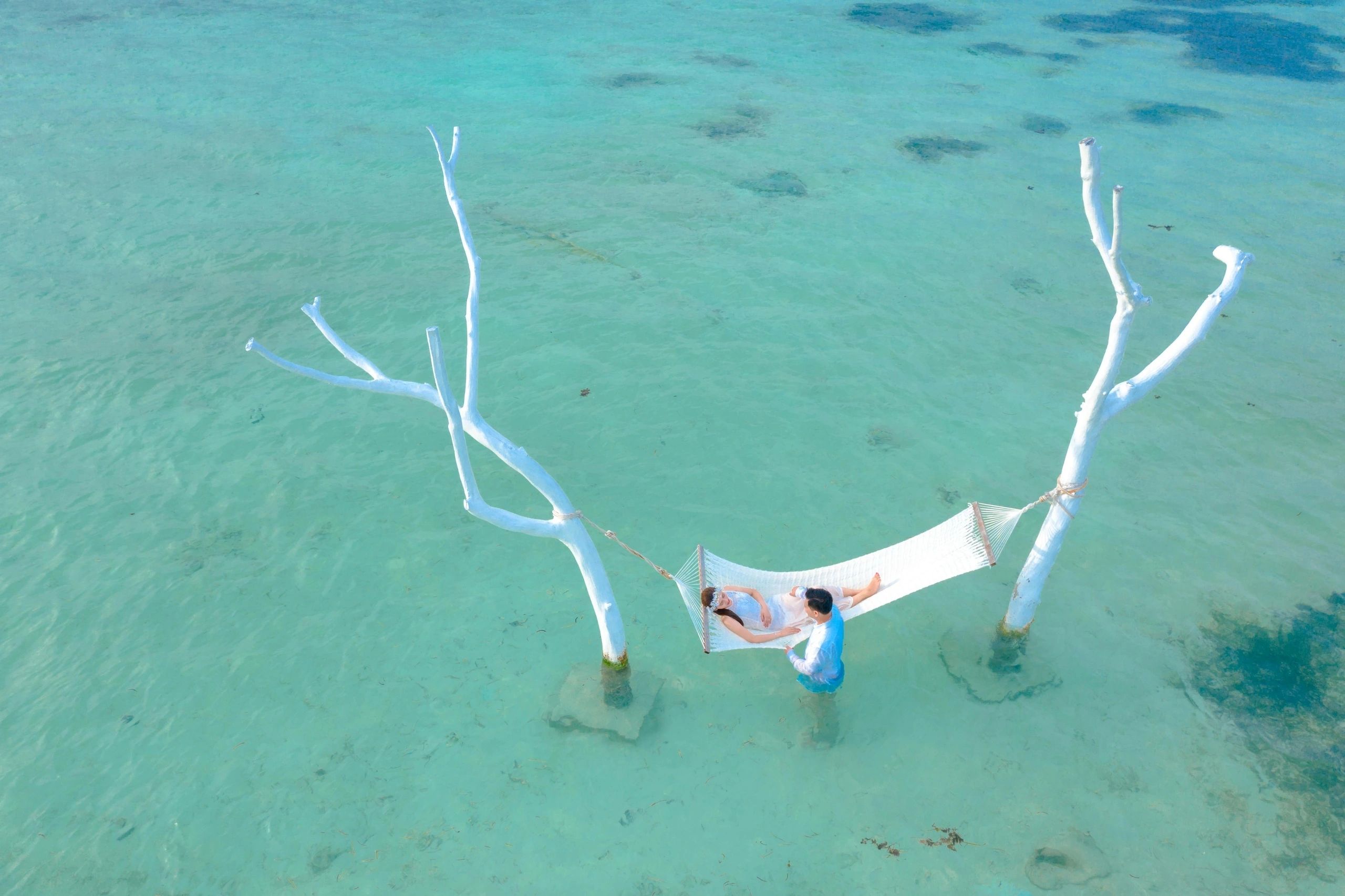 Couple relaxing on hammock over the ocean