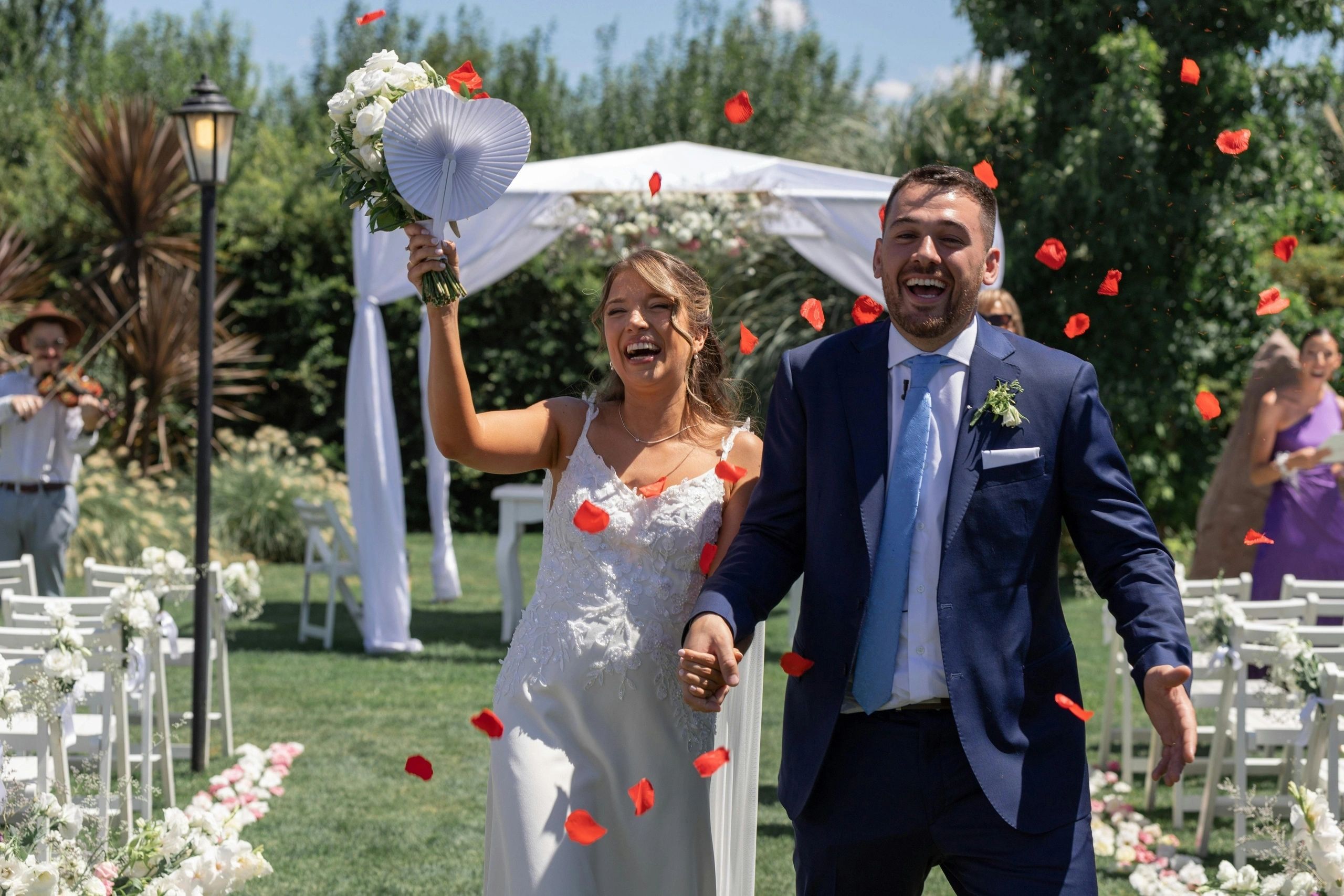 Newlyweds walking together through a flower-filled garden