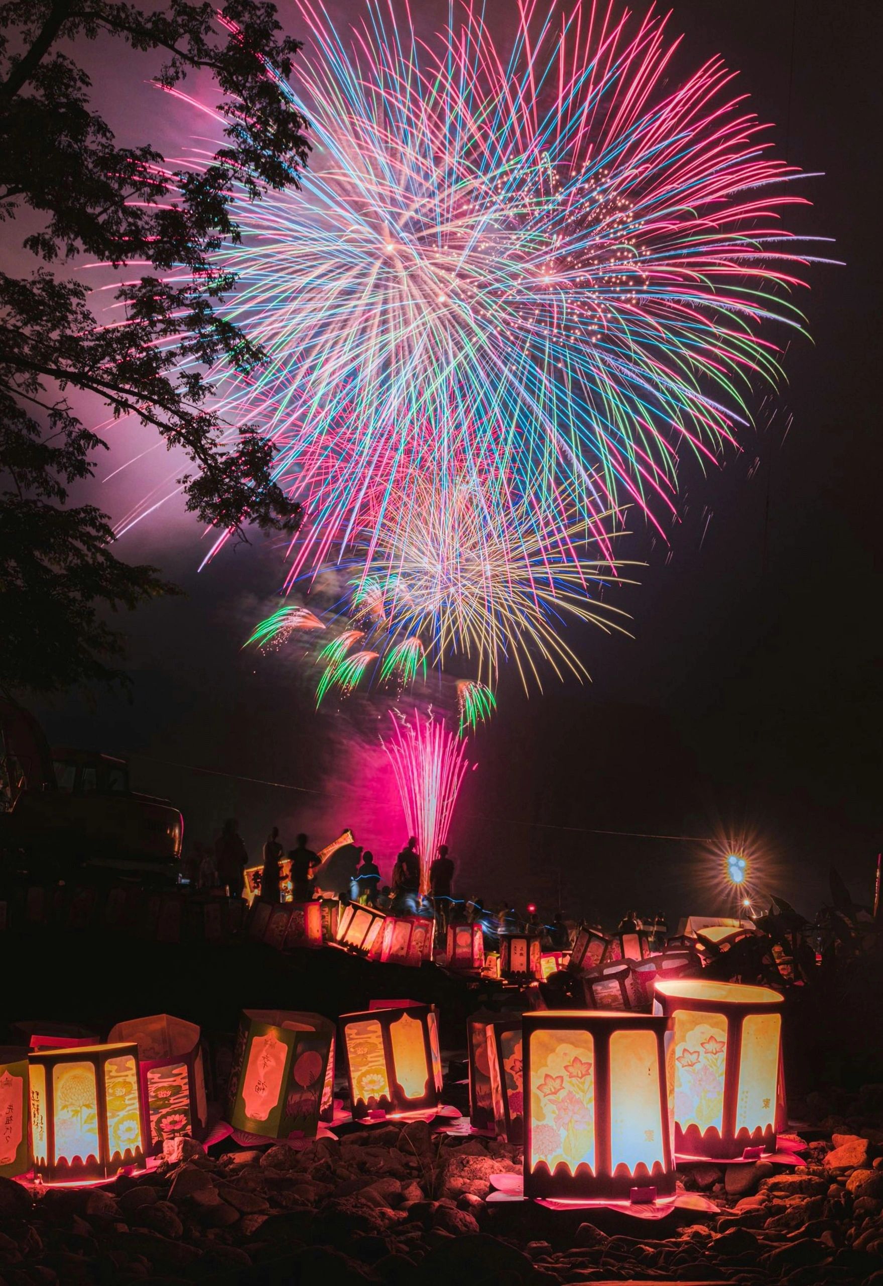Fireworks over a brightly lit evening venue