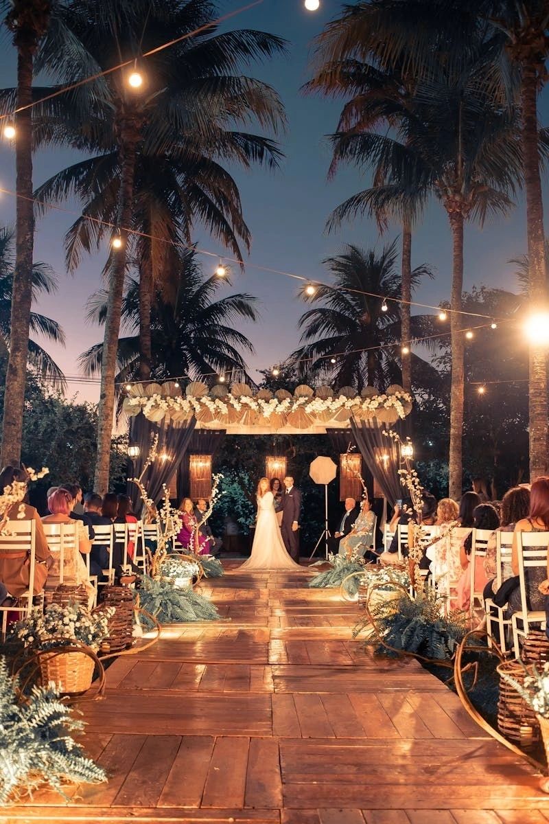 Couple beneath string lights at a tropical evening reception