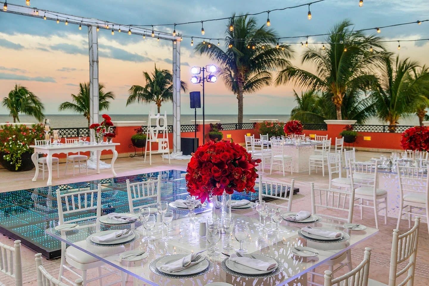 Outdoor reception table with red floral centrepieces