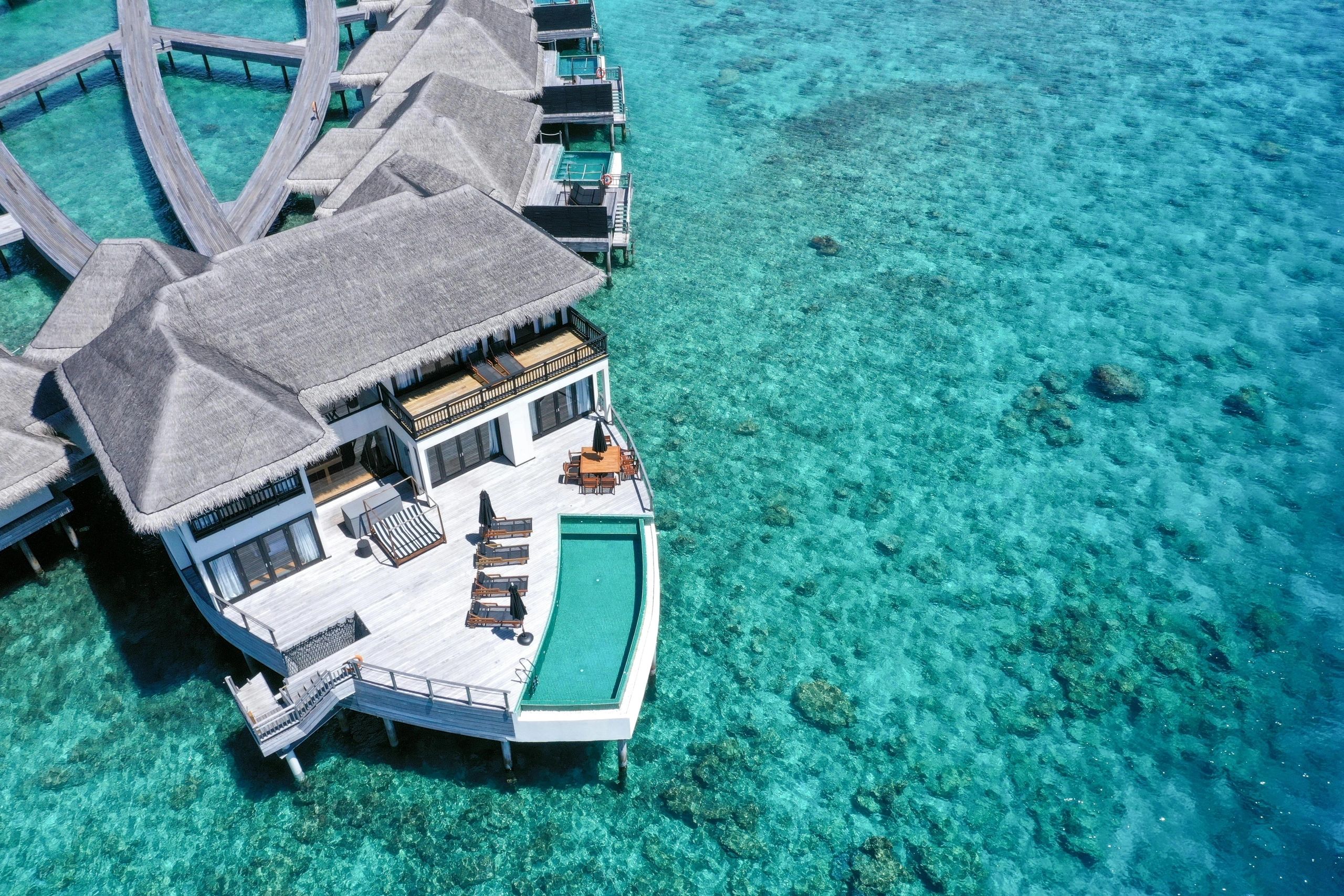 Overwater villa with a pool above a clear lagoon