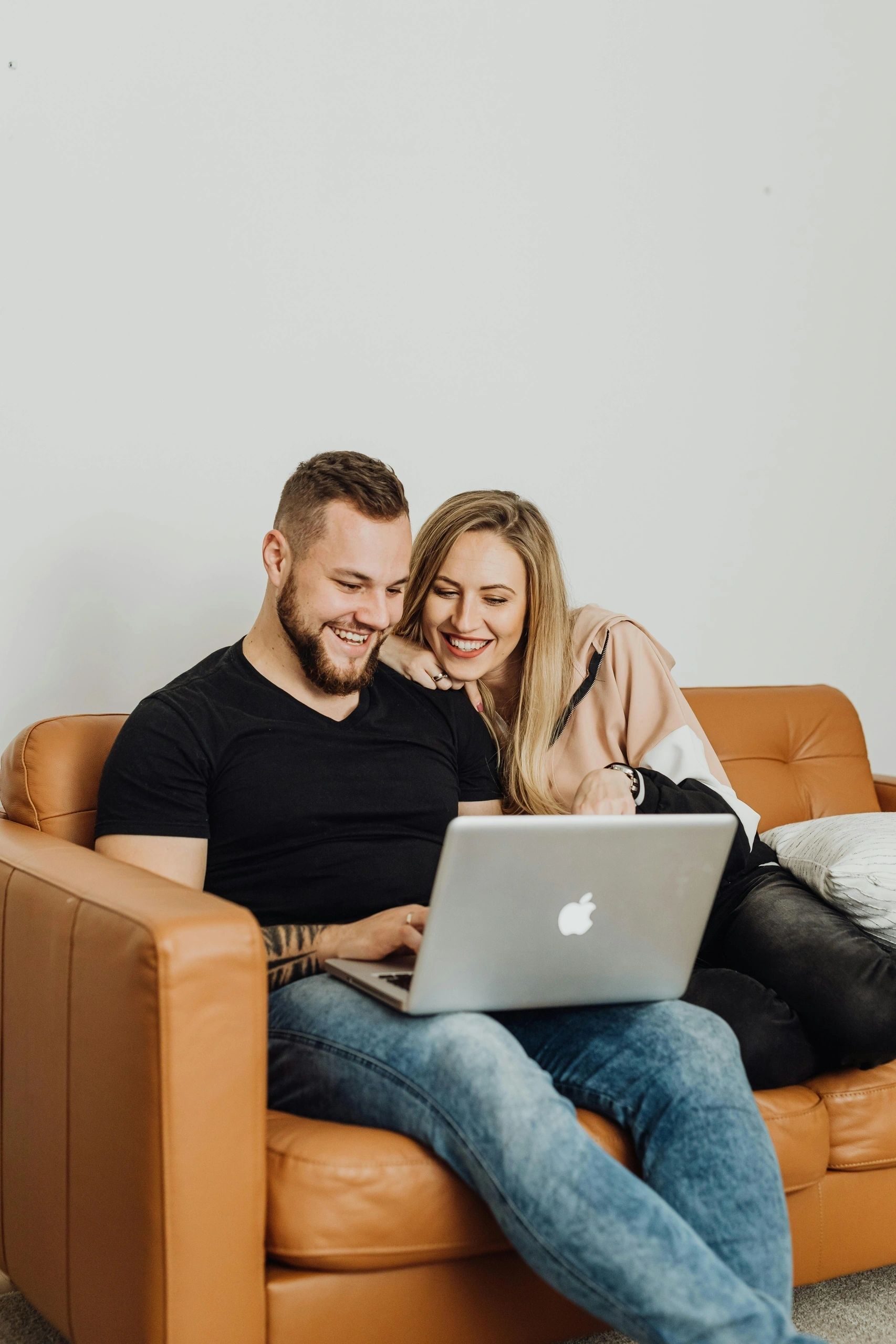 Couple relaxing together with a laptop on a sofa