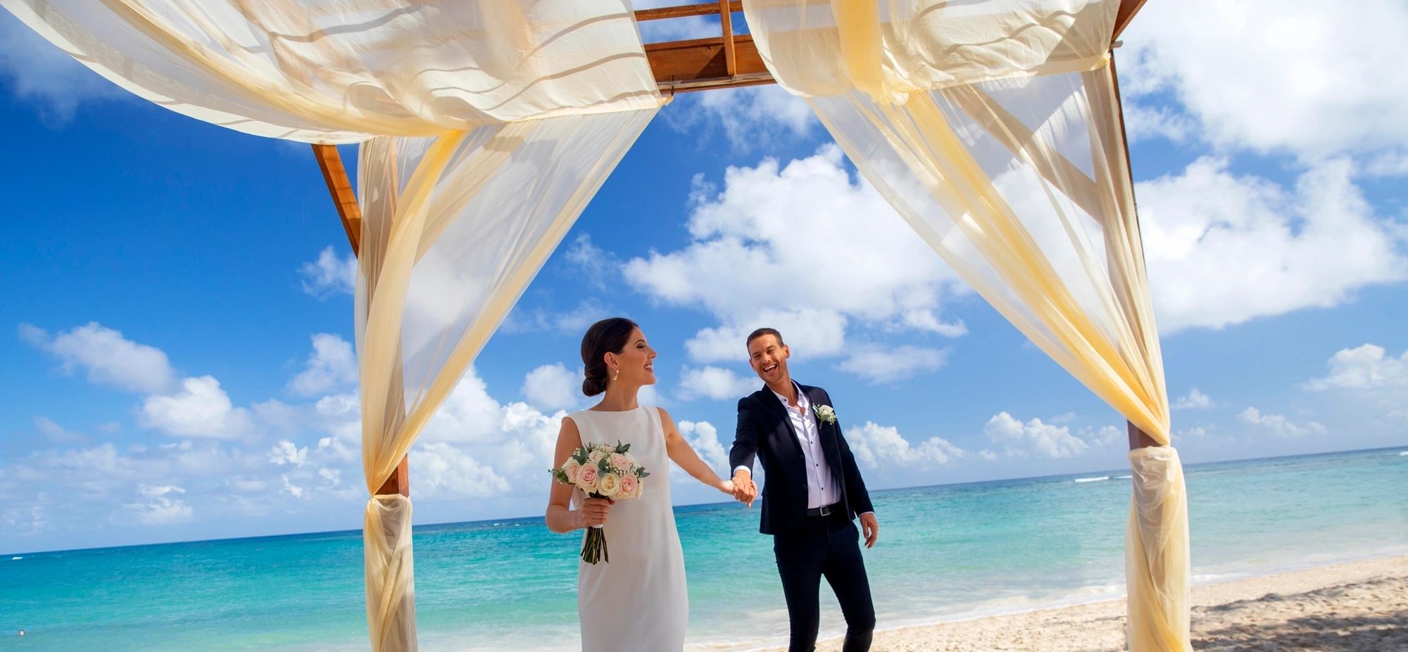 Royalton Grenada destination wedding couple on the beach with turquoise Caribbean waters behind them