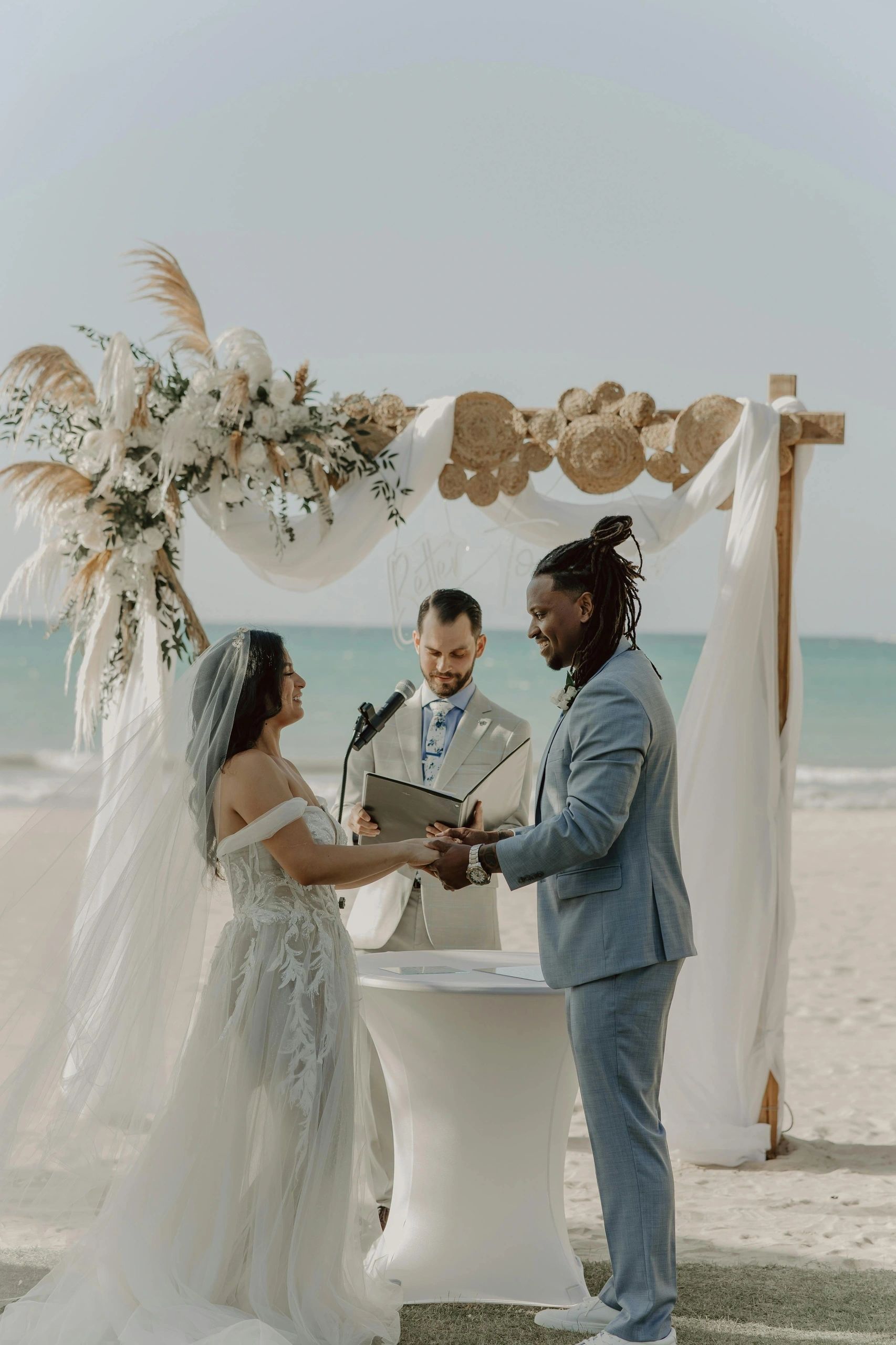 Newlyweds beneath an outdoor ceremony arch