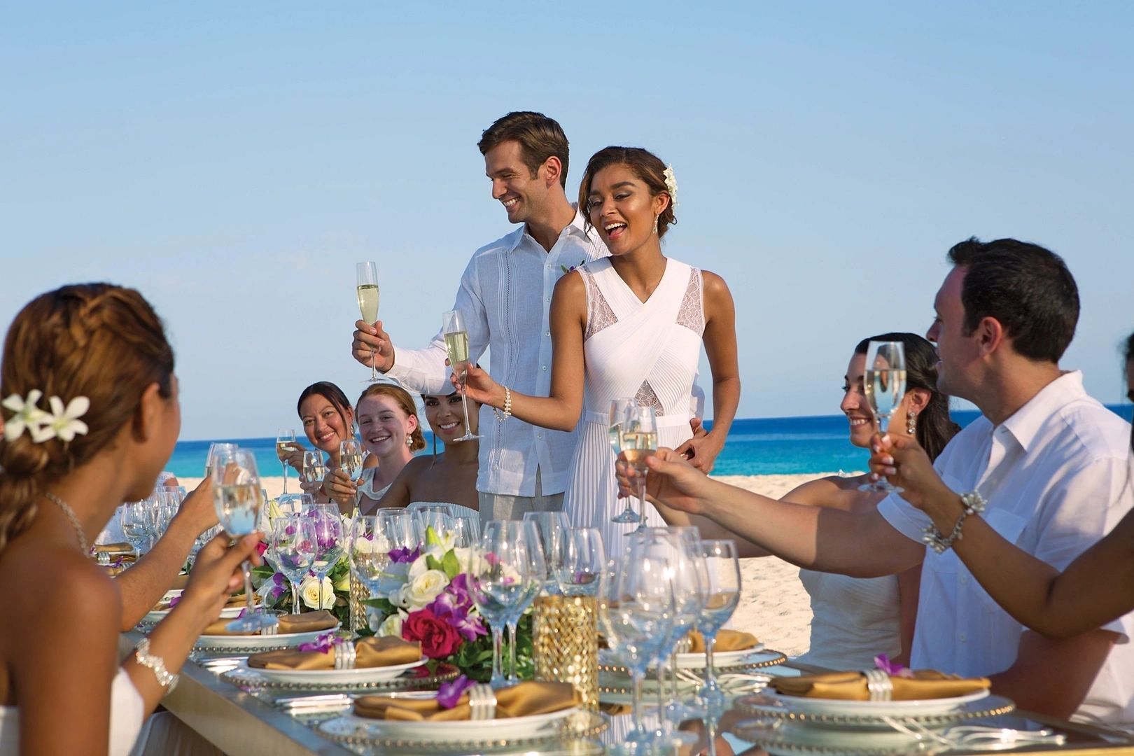 Wedding couple greeting guests at a colourful reception table