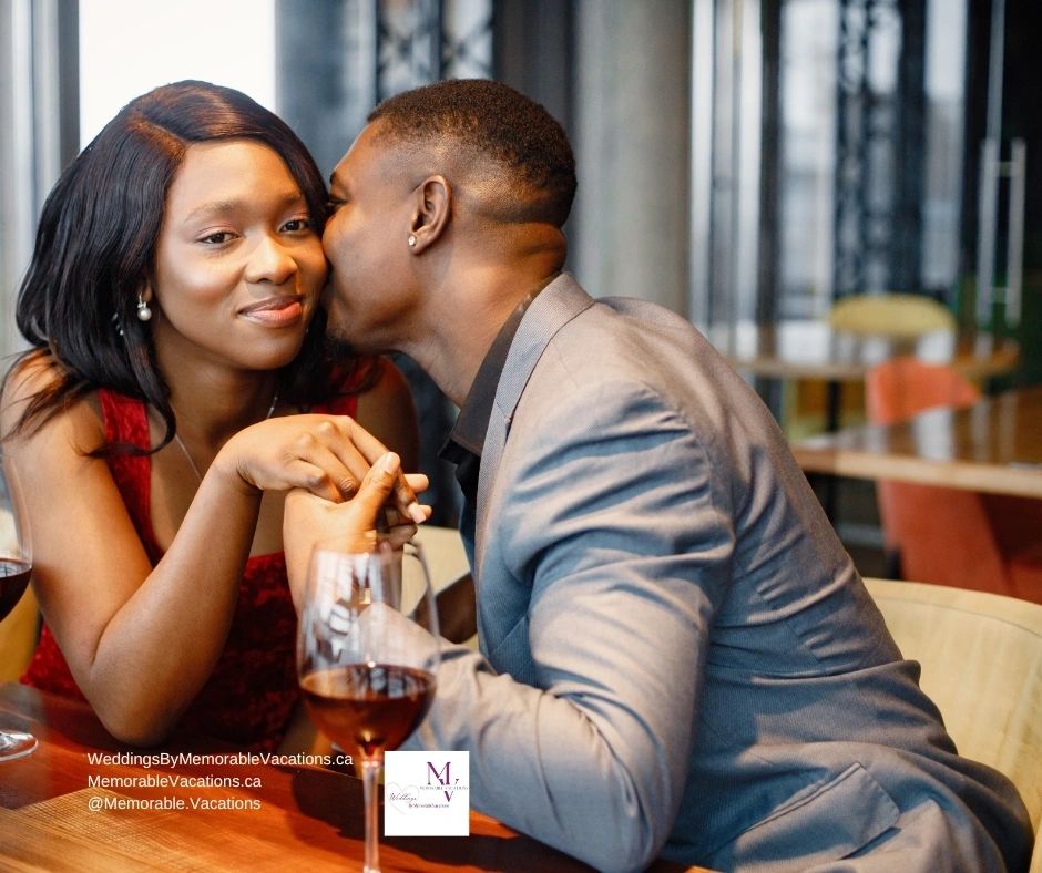 Couple sharing a kiss over drinks at an outdoor table