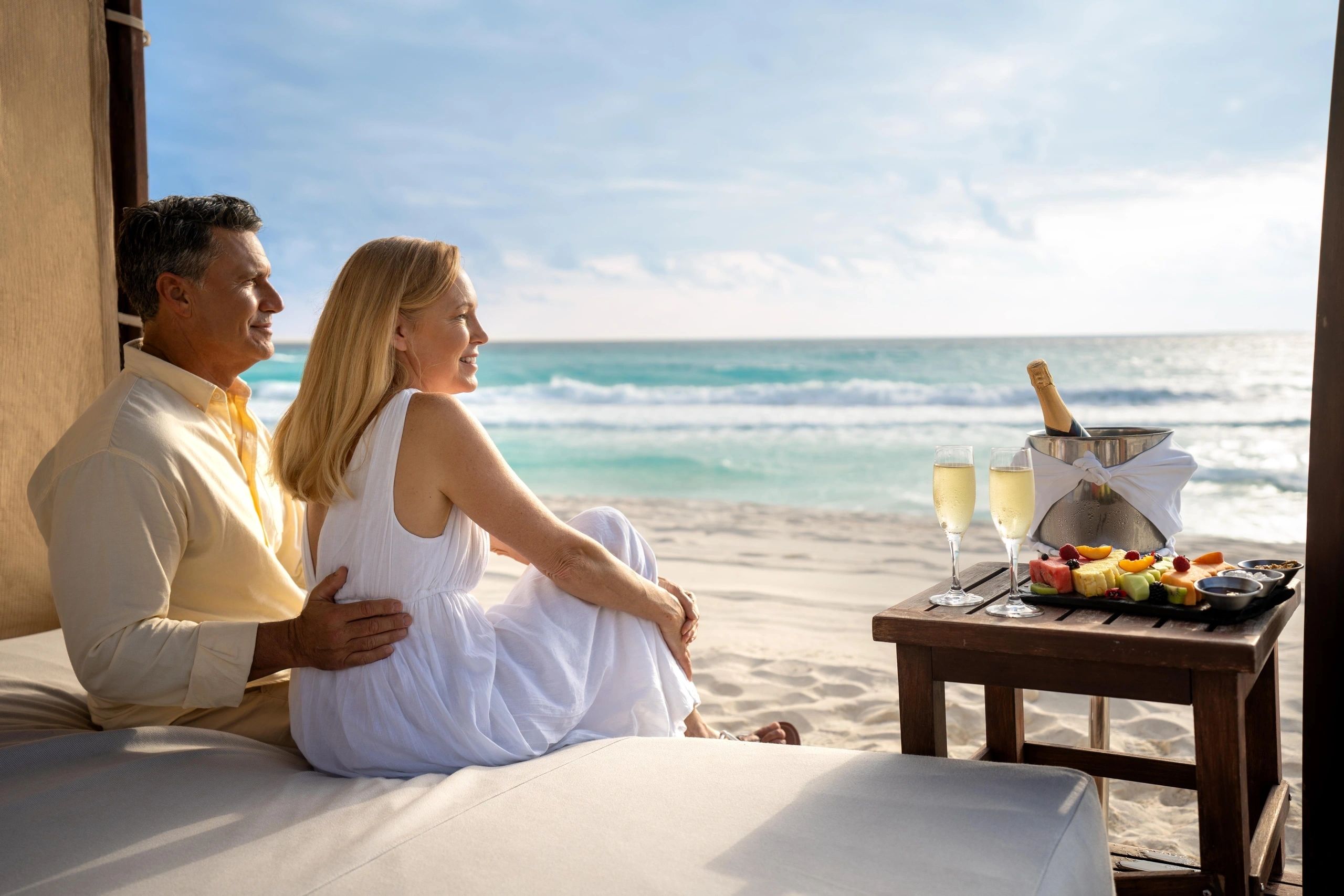 Couple relaxing in a shaded cabana facing the beach