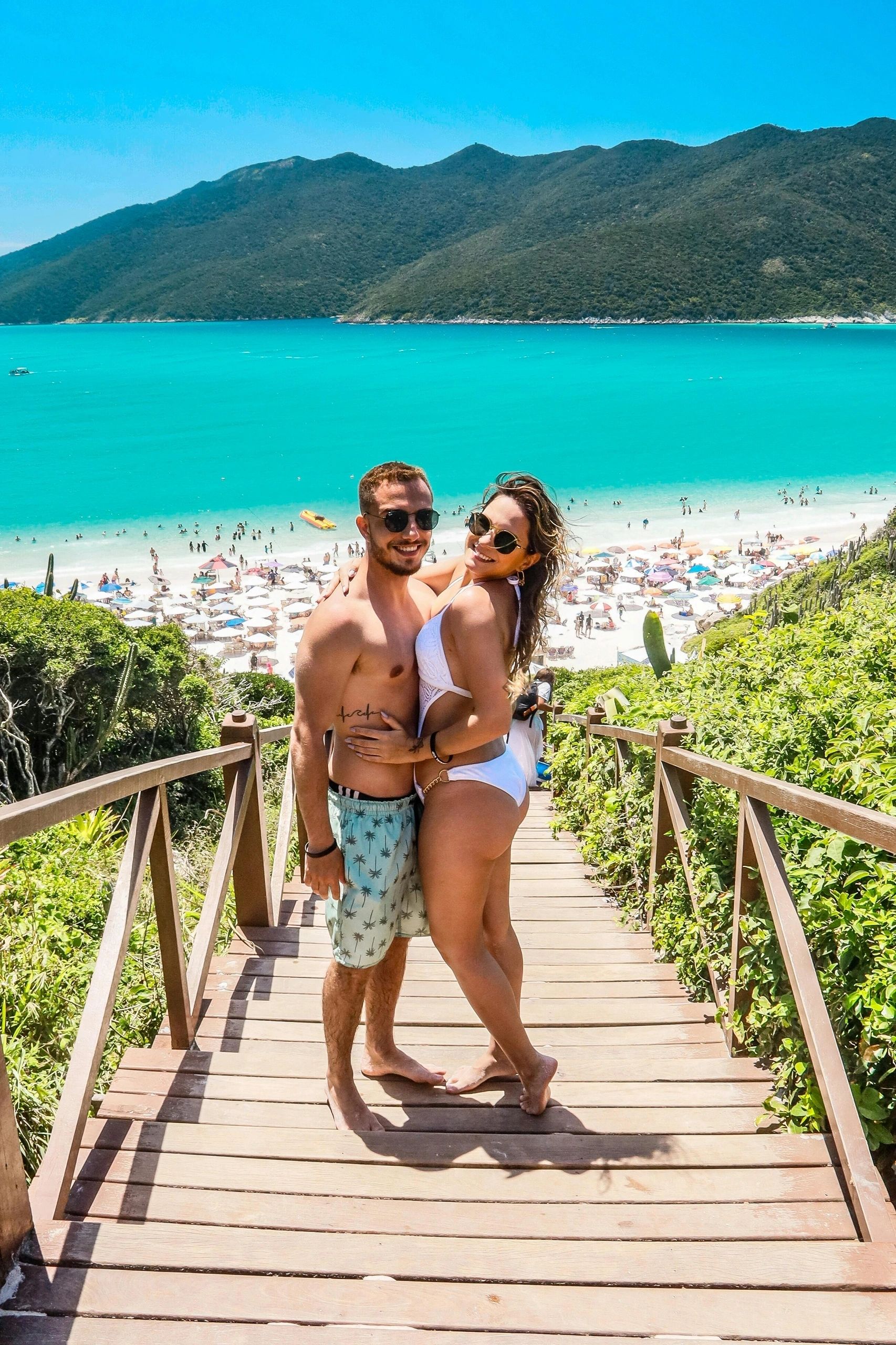 Couple on a wooden walkway beside turquoise water