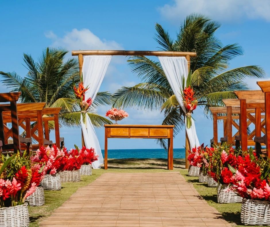 Tropical ceremony arch decorated with red and orange flowers