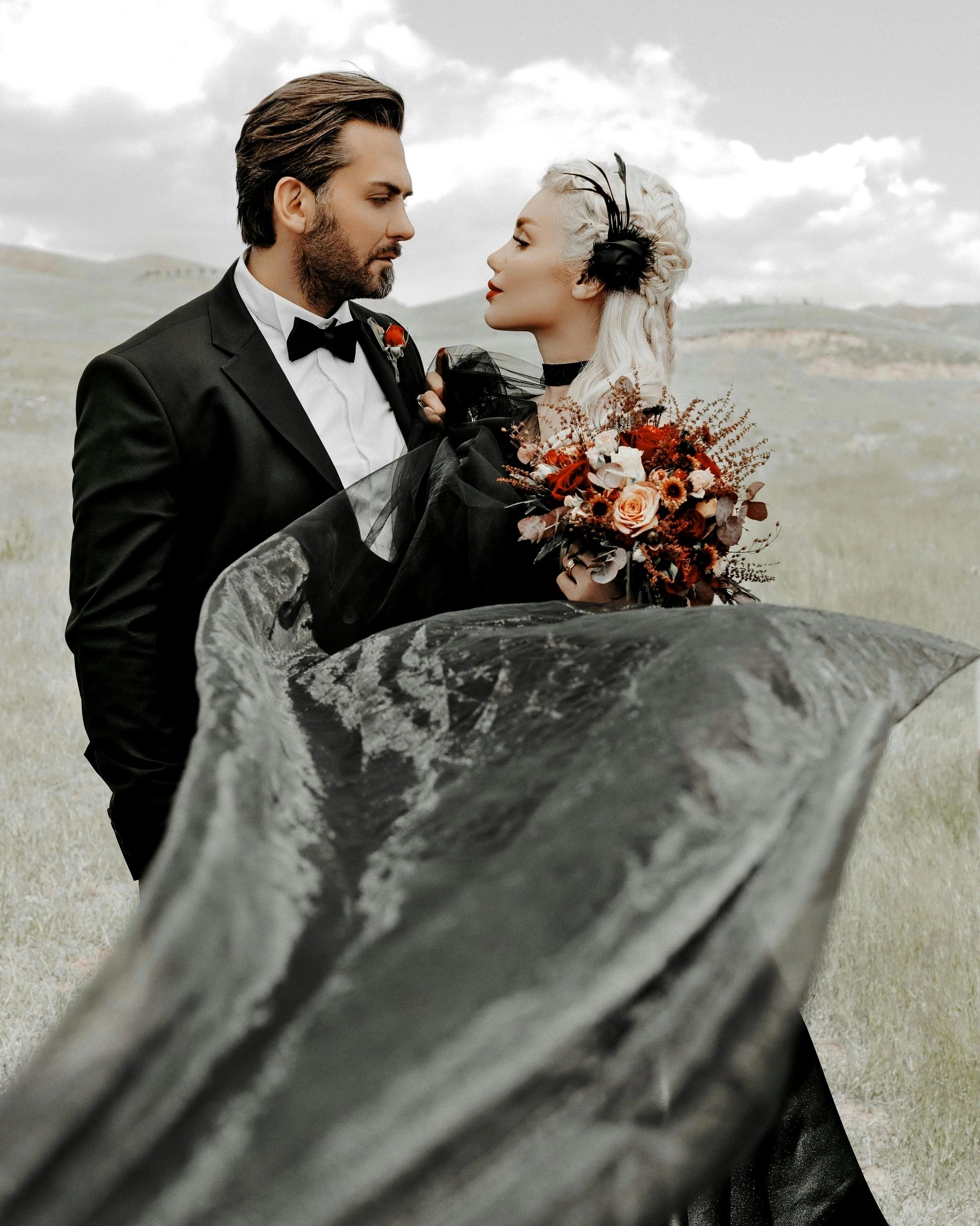 Newlyweds holding flowers outdoors